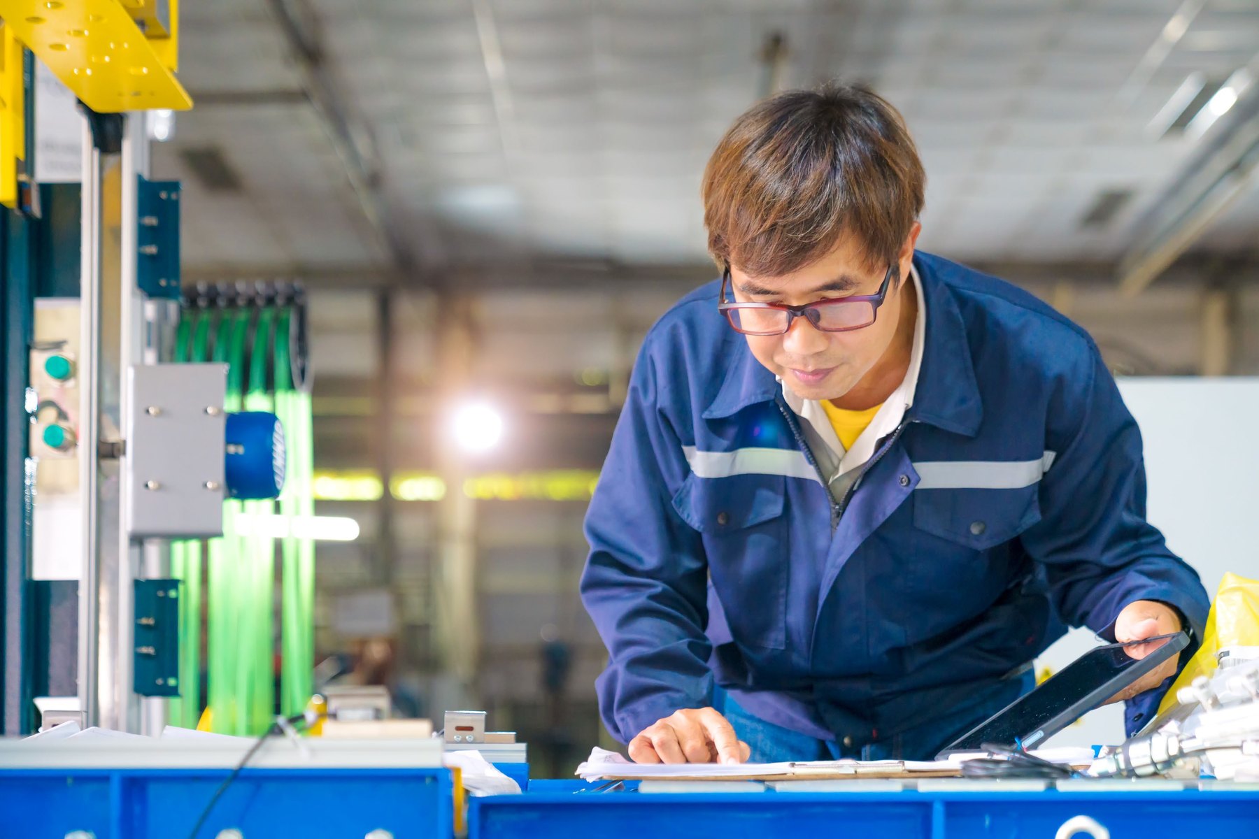 ช่างเทคนิคทำงานกับเครื่องจักรในโรงงาน / A technician working with production machinery